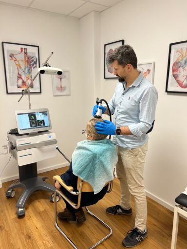 Transkranielle Pulsstimulation – TPS-Behandlung in Hannover Ambulante TPS-Behandlung: Ein Handstück wird zur Abgabe akustischer Druckimpulse am Kopf eines Patienten positioniert.